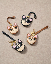 Close-up of handmade Chihuahua leather bag charm — hand-stitched visible edges on French Alran goatskin, 18K gold-plated cube hardware. STICKYZOO.