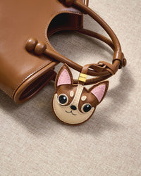 Chihuahua leather bag charm shown in both attachment options — handmade French Alran goatskin, dual attachment. STICKYZOO Amsterdam design.