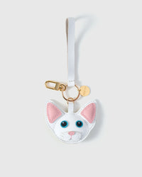 Overhead — Devon Rex cat charm editions side by side. Finished one at a time, by hand. Real French Alran goatskin.