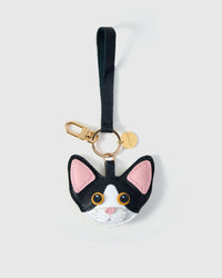 Devon Rex cat charm in both leather strap and 18K gold-plated keychain editions — strap loop for bags, or clip for keys.