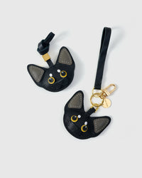 Tight detail of the all-black Devon Rex with grey ears — gold-yellow eyes, real French leather. Hand-cut over three days.