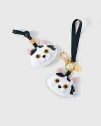 Both editions of the Dragon Li side by side — leather strap loop for bags, or 18K gold-plated keychain clip.