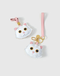 Both editions of the orange-eye Maine Coon side by side — leather strap loop for bags, or 18K gold-plated keychain clip.