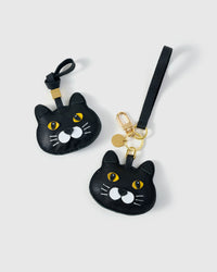 Both editions of the Chubby Midnight British Shorthair side by side — leather strap loop for bags, or 18K gold-plated keychain clip.