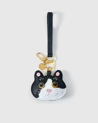 Black Muse British Shorthair on an 18K gold-plated keychain clip with engraved STICKYZOO disc — clips to keys, bags or backpacks. Real French leather, 3 days by hand.