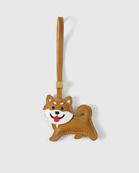 Shiba Inu charm handmade from French Alran genuine goatskin and French suede — real full-grain leather from Tarn, since 1903. 3 days of hand-cutting, hand-stitching, hand-layering. Arrives in luxury gift packaging. Designed in Amsterdam.