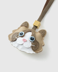 Tight close-up of the Classic Ragdoll face — vivid blue eyes in real leather, tan-brown markings, pink nose, white inner ears. Every panel by hand.