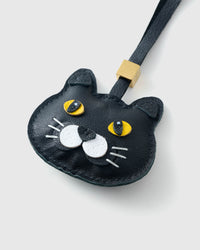 Tight close-up of the Chubby Midnight face, angled — wide gold eyes in real leather, full chubby cheeks, white whisker-pad accents. Every panel by hand.