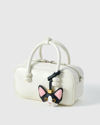 Black-and-white Devon Rex cat charm in strap and keychain editions — real French leather, finished one at a time by hand.