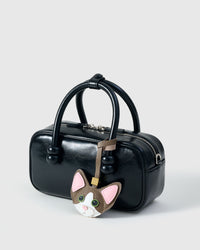 Taupe Devon Rex on a glossy black box bag, side angle — real French leather, 3 days by hand.