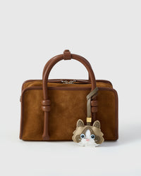 Classic Ragdoll charm styled on a warm brown suede top-handle bag, front — the small piece that turns a simple bag into a personal one.