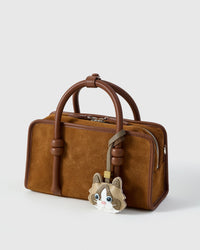 Classic Ragdoll on a warm brown suede top-handle bag, side angle — real French leather, 3 days by hand.