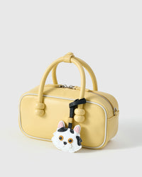 Dragon Li on a soft-yellow box bag, side angle — 5,000+ reviews across STICKYZOO. Real French leather, 3 days by hand.