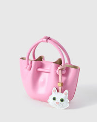 White Maine Coon charm on a soft pink bucket bag, side angle — loved by thousands of cat lovers. Real French leather, 3 days by hand.