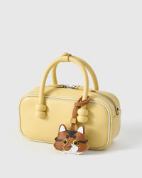 Orange long-hair tabby on a soft-yellow box bag, front view — loved by thousands of cat lovers. Real French leather, 3 days by hand.