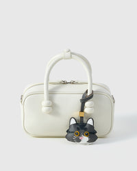 Gray-and-white long-hair tabby styled on a top-handle bag, front — a small, specific piece that turns a simple bag into a personal one.
