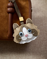 Classic Ragdoll close on a warm brown suede top-handle bag, side angle — Real French leather, 3 days by hand.