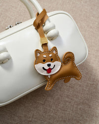 Wear the Shiba Inu charm on a bag with the leather strap loop, or clip it to keys with the 18K gold-plated keychain clip.