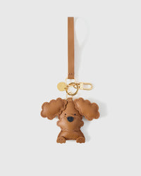 Close-up of handmade Poodle leather bag charm — hand-stitched visible edges on French Alran goatskin, 18K gold-plated cube hardware. STICKYZOO.
