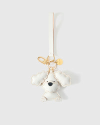 Close-up of handmade Poodle leather bag charm — hand-stitched visible edges on French Alran goatskin, 18K gold-plated cube hardware. STICKYZOO.
