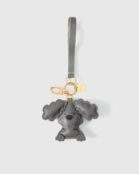 Close-up of handmade Poodle leather bag charm — hand-stitched visible edges on French Alran goatskin, 18K gold-plated cube hardware. STICKYZOO.