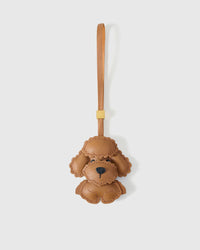 Handmade teddy-style Poodle leather bag charm by STICKYZOO — hand-cut, hand-stitched, hand-layered French Alran goatskin over 3 days in caramel. Designed in Amsterdam.