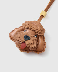 Close-up of handmade Poodle leather bag charm — hand-layered topknot curls in French Alran goatskin, hand-stitched edges. STICKYZOO Amsterdam design.