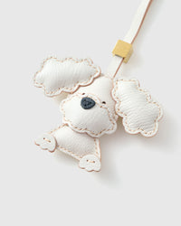Handmade Poodle leather bag charm clipped to a handbag — French Alran goatskin, 3-day artisan build. STICKYZOO Amsterdam design.