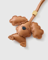 Handmade Poodle leather bag charm clipped to a handbag — French Alran goatskin, 3-day artisan build. STICKYZOO Amsterdam design.
