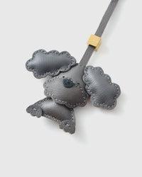 Handmade Poodle leather bag charm clipped to a handbag — French Alran goatskin, 3-day artisan build. STICKYZOO Amsterdam design.
