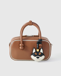 Wear the black-and-orange Tokyo Shiba charm on a bag with the leather strap loop, or clip it to keys with the 18K gold-plated keychain clip.