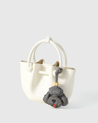 Handmade Poodle leather bag charm clipped to a handbag — French Alran goatskin, 3-day artisan build. STICKYZOO Amsterdam design.