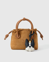 Close-up of handmade French Bulldog leather bag charm — hand-layered face panels in French Alran goatskin, embroidered eyes. STICKYZOO 3-day build.