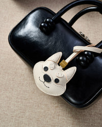 Every panel of the white Tokyo Shiba charm is cut by hand and stitched through real French leather. Layered slowly for depth — no prints, no stamps.