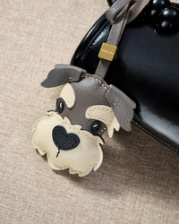 Every panel of the schnauzer charm is cut by hand and stitched through real French leather. Layered slowly for depth — no prints, no stamps.