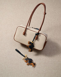 The dachshund charm is made from genuine French Alran goatskin and French suede — real full-grain leather. Never vegan. Never synthetic. The difference shows.