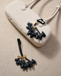 The triple schnauzer charm is made from genuine French Alran goatskin and French suede — real full-grain leather. Never vegan. Never synthetic. The difference shows.