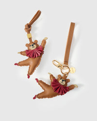 Both editions of the ballet bear charm — leather strap loop for bags, or 18K gold-plated keychain clip.
