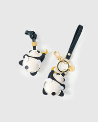 Both editions of the moon panda charm — leather strap loop for bags, or 18K gold-plated keychain clip.