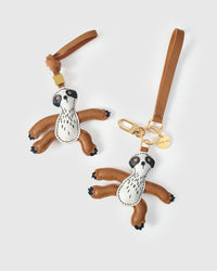 Both editions of the sloth charm — leather strap loop for bags, or 18K gold-plated keychain clip.