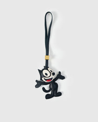 The Cat charm handmade from French Alran genuine goatskin — black body in mid-dance pose, white face with big eyes, red smile, black leather strap. Three days by hand. Arrives in luxury gift packaging. Designed in Amsterdam.
