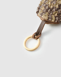 Scaled charm — five days of hand-work per piece. Built slow.