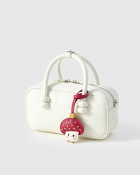 STICKYZOO Mushroom Charm clipped to a handbag — handmade French Alran goatskin in red with silver studs. 3-day artisan build.