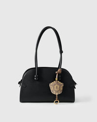 Scaled charm styled on a bag — a small, specific piece that turns a simple bag into a personal statement.