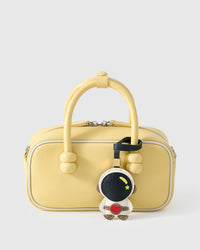 ASTRONAUT CHARM charm styled on a bag — a small, specific piece that turns a simple bag into a personal one.