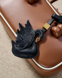 Handmade leather swan charm on a leather bag — French Alran goatskin, hand-layered and hand-stitched by one artisan over 3 days. Loved by thousands of bag charm collectors. STICKYZOO Amsterdam design.