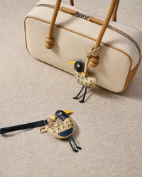 Close-up of the gull — hand-stitched arrow feather detail, navy chest accent, yellow beak. Every panel by hand.