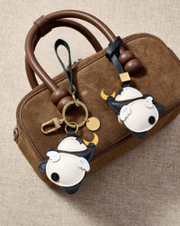 Close-up of the moon panda charm — hand-cut and hand-stitched panels of French Alran goatskin. Every layer by hand.