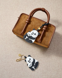 Close-up of the panda charm — hand-cut and hand-stitched panels of French Alran goatskin. Every layer by hand.