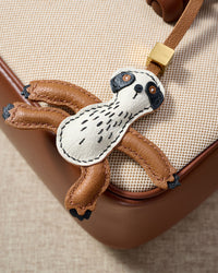 SLOTH CHARM charm styled on a bag — a small, specific piece that turns a simple bag into a personal one.